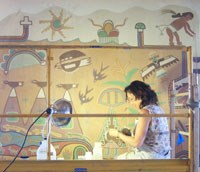 Flavia Benato works on a Kabotie mural in the dining room