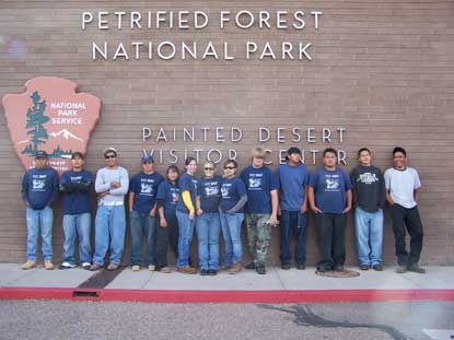 YCC crew lined up in front of Visitor Center and NPS Arrowhead sign