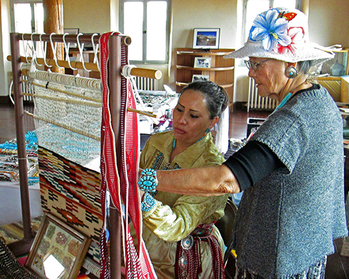 Alice and Angeline weaving on a traditional Navajo loom
