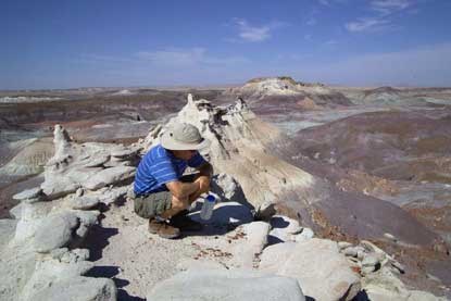 artist sits on erosional feature
