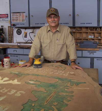 Paul Cox works on large, wooden NPS Arrowhead
