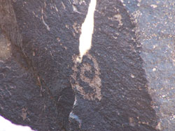 carved spiral shape in rock with beam of light touching top