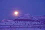 moon rising over badlands