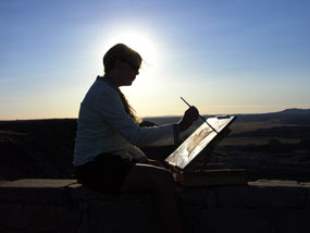 Williams is backlit by the setting sun as she paints. Williams is backlit by the setting sun as she paints.