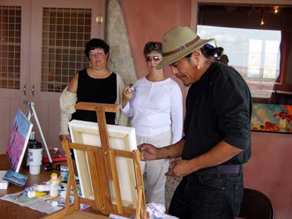 Begay paints while visitors watch
