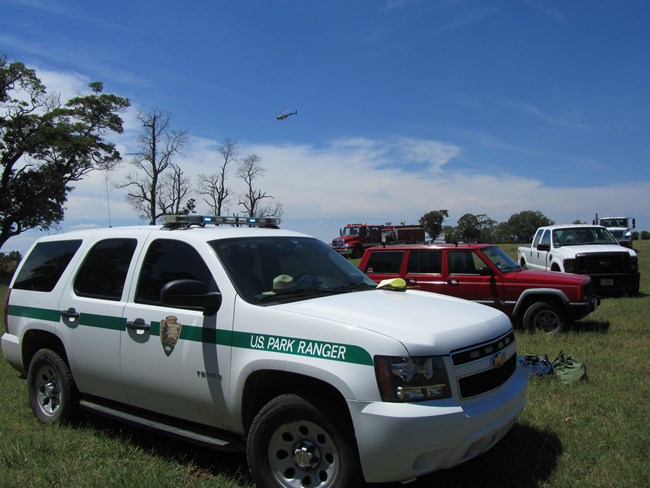 Fire support vehicles from multiple agencies, including a helicopter.