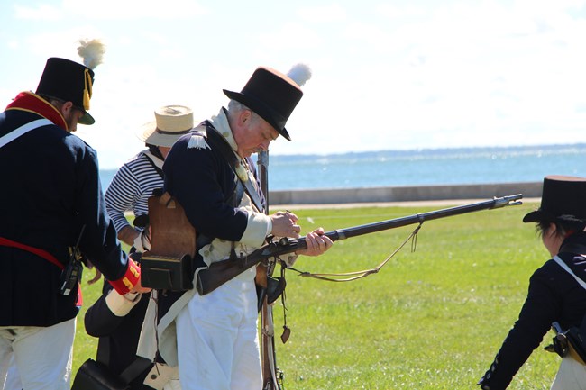 A reenactor prepares his musket for a demonstration.
