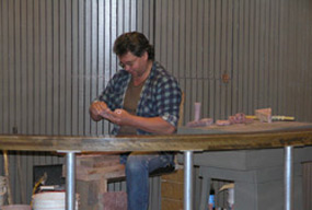 Cultural demonstrator carving a pipe