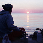 A visitor enjoys the sunset along Lake Superior while backpacking at Pictured Rocks National Lakeshore.