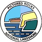 This logo for Pictured Rocks National Lakeshore features colorful cliffs and blue water.