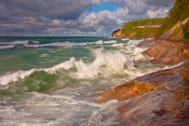 Waves crashing against cliff shoreline