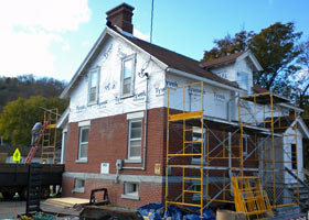 View of the rear entrance of Munising Range Light keepers dwelling with scaffolding in place during exterior work.