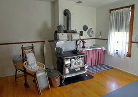 The light keepers kitchen at Raspberry Island Lighthouse, Apostle Islands National Lakeshore, includes a large woodburning cookstove, pots, ironing board, and cooking items.