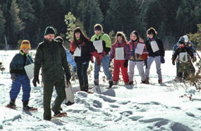 Park Ranger Dave Kronk leads a snowshoe hike with a group of school children.