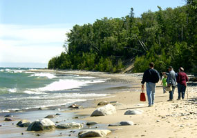 Visitors stroll along Twelvemile Beach as Lake Superior waves roll gently to shore. Visitors stroll along Twelvemile Beach as Lake Superior waves roll gently to shore.