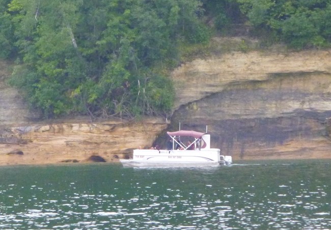 Pontoon boat along cliffs