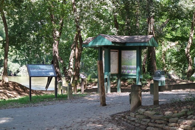 Kiosk and wayside exhibit on a trail by the river
