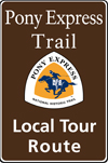 Brown tall rectanglular highway sign with white words: Pony Express Trail Local Tour Route and white, orange and blue trail logo of rider.
