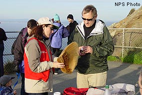Docent holding gray whale baleen talking with a visitor.