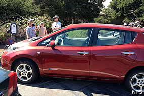 A family charging their electric vehicle at Bear Valley Visitor Center.