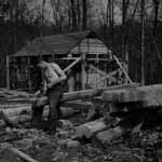 a ccc boy hard at work in front of a cabin