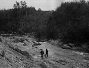 Two men walking along Quantico Creek in the early 1900s