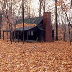historic cabin surrounded by fall foliage