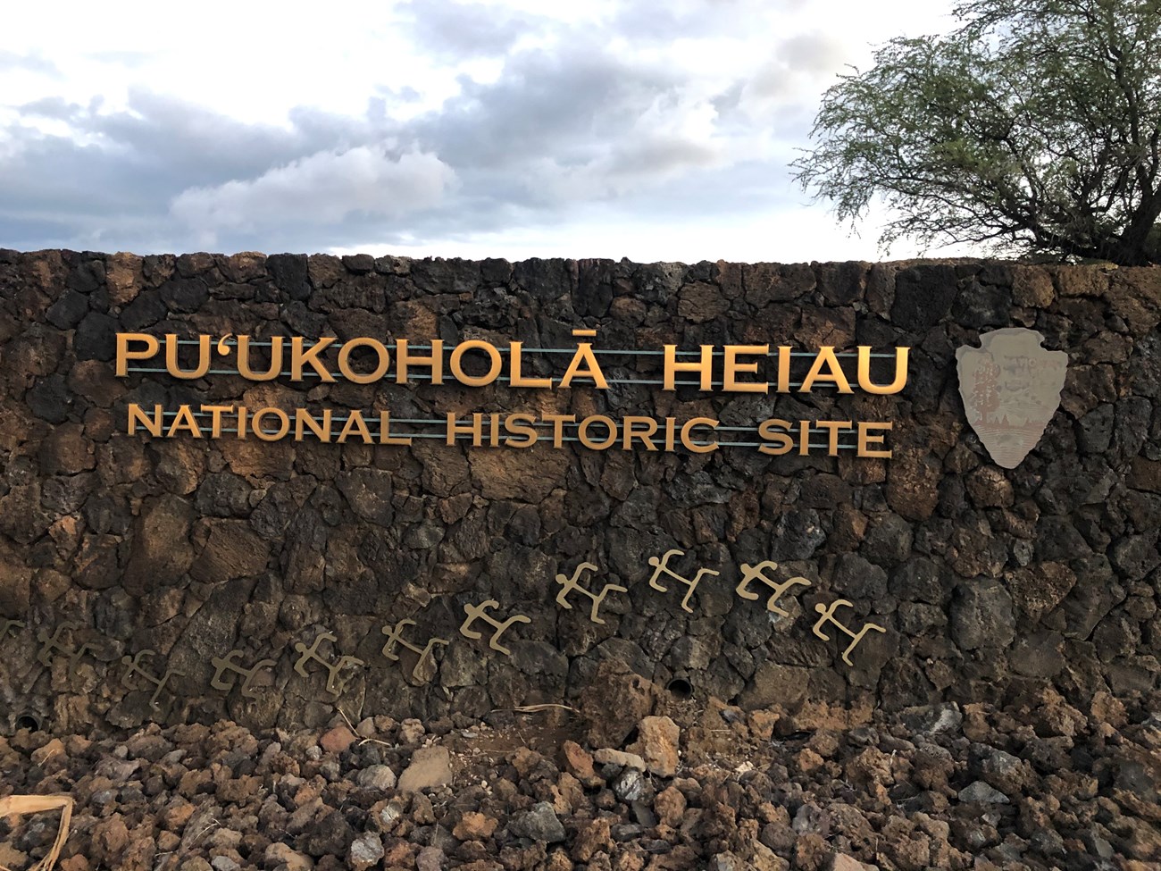 Park name displayed with petroglyphs and an arrowhead on the entrance wall to the visitor center.