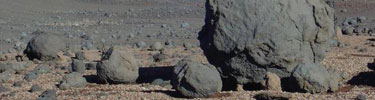 These rounded black rocks are called volcanic bombs.