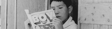 Boy reading the Funnies. Photo by Dorothea Lange.