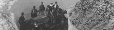 Park visitors and their car in 1921 with snow birms lining the Paradise Road.