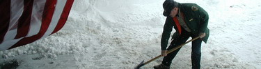 Volunteer Lloyd Smith shovels snow at the Jackson Visitor Center