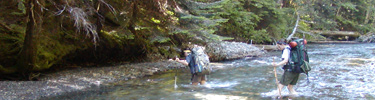 Backpacks fording Elwha River