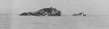 S.S. Quinault Victory with her propeller sticking out of the water on the right
