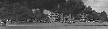 The USS Phoenix steams down the Ford Island channel past the USS West Virginia (l) and the USS Arizona (r).