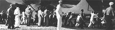 Navy personnel on the seaplane ramp at Kaneohe Naval Air Station move a damaged PBY-5 seaplane to safety.
