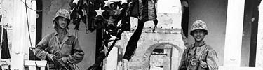 These 3rd Division Marines found this American flag in the ruins of a building on the Plaza de Espana and strung it across the entrance