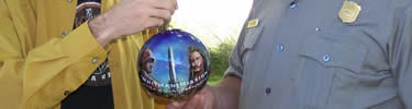 artist handing 2007 Christmas ornament to park superintendent