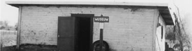 historic photo of one room adobe building which was used as a temporary museum