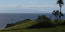 The peak of Mauna Loa is visible across the ocean in this coastal view at Kipahulu.