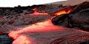 Glowing, reddish-orange lava flowing on the surface at Hawai`i Volcanoes National Park