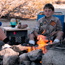Photo of camper at campfire.