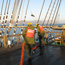Two deckhands in orange vests handling lines on BALCLUTHA'S deck.