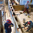 Worker removing rotten deck planking.