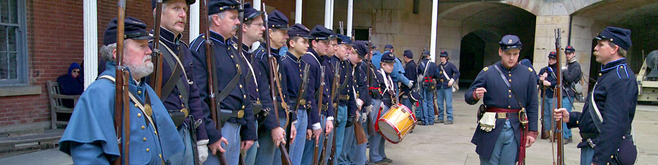 Line of Civil War re-enactors in uniforms with guns at Fort Point