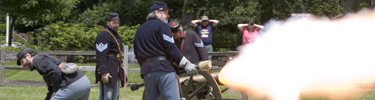 Staff and volunteers team up to fire the mountain howitzer