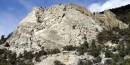 View of a granite mountain with trees around the base. View of a granite mountain with trees around the base.