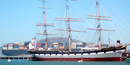 Balclutha moored at the pier with a modern container ship passing behind her. Balclutha moored at the pier with a modern container ship passing behind her.