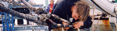 A volunteer works on repairing and maintaining Balclutha's rigging.