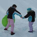 Two young girls play in the snow